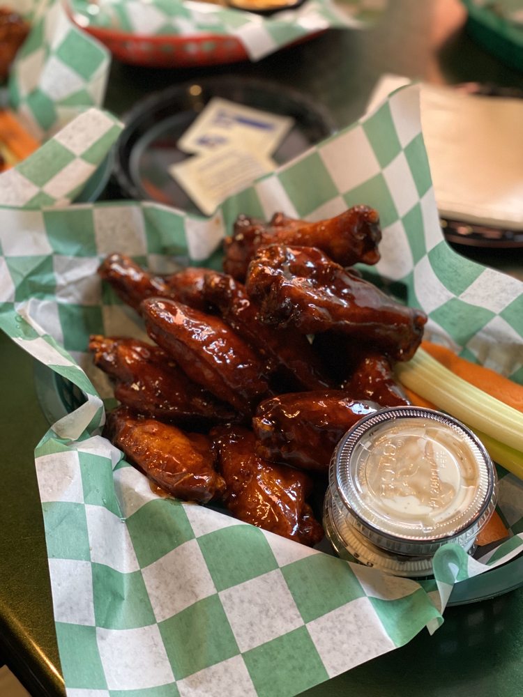 A basket of wings with carrots, celery, and dipping sauce