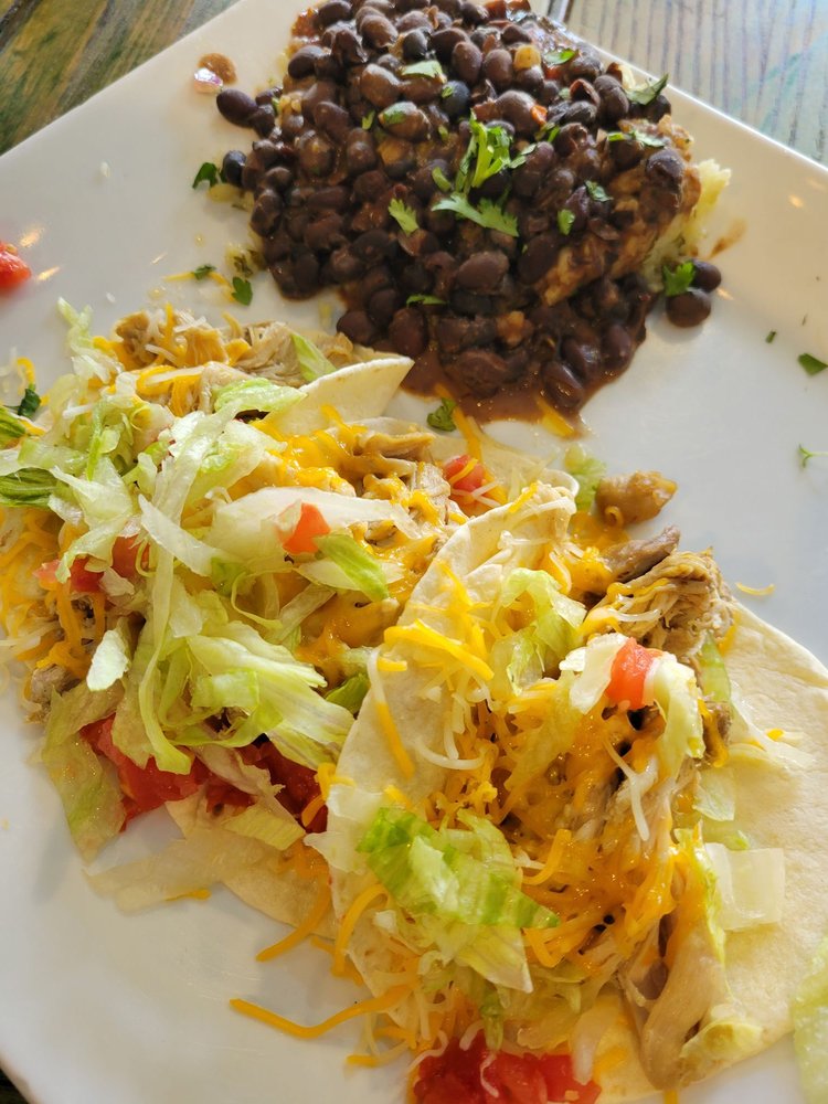 A plate of chicken tacos with beans