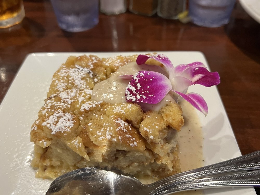 a plate of bread pudding with a flower on top