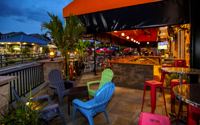 exterior of earth, wood and fire fallston, patio with lawn chairs, stools, and a bar