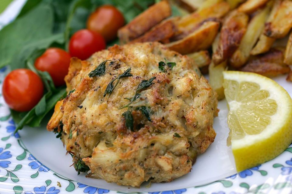 a crabcake with a lemon wedge and fries