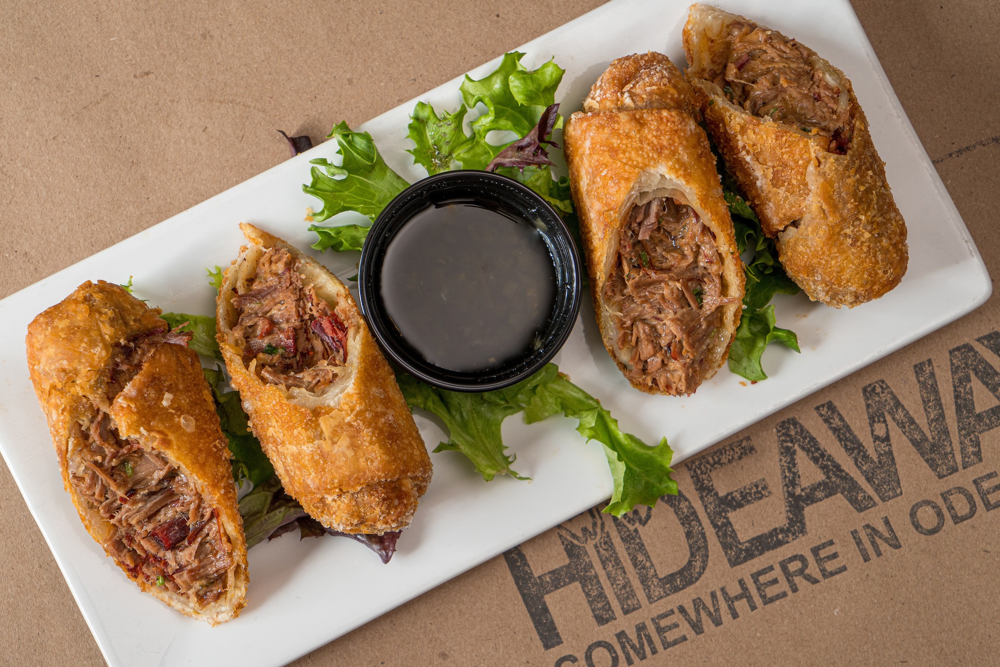 a plate of fried egg rolls with dipping sauce