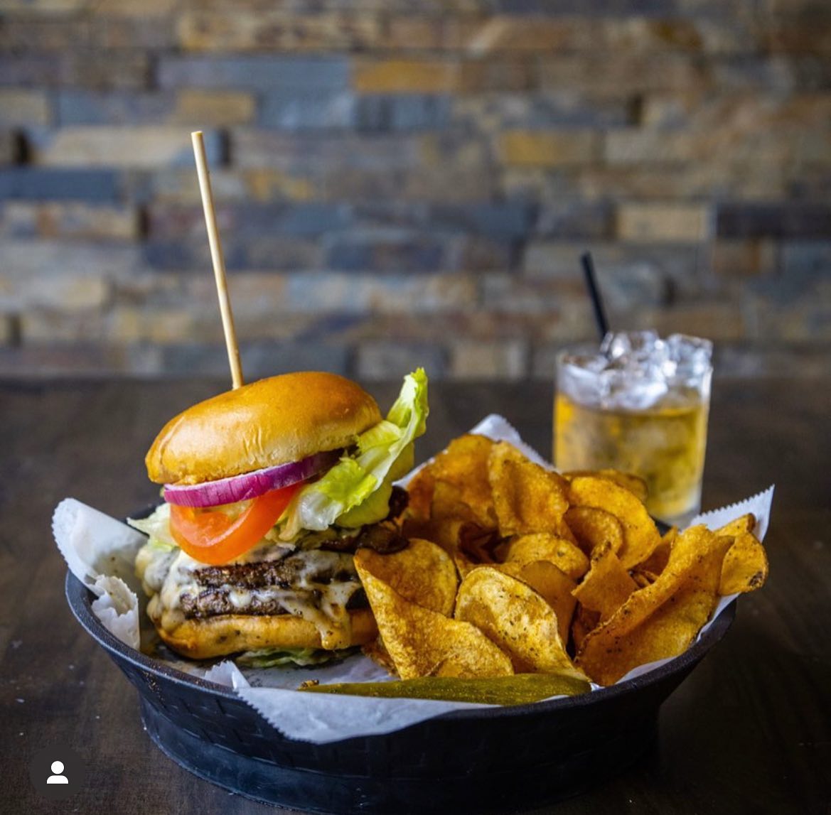 a burger with potato chips and a drink