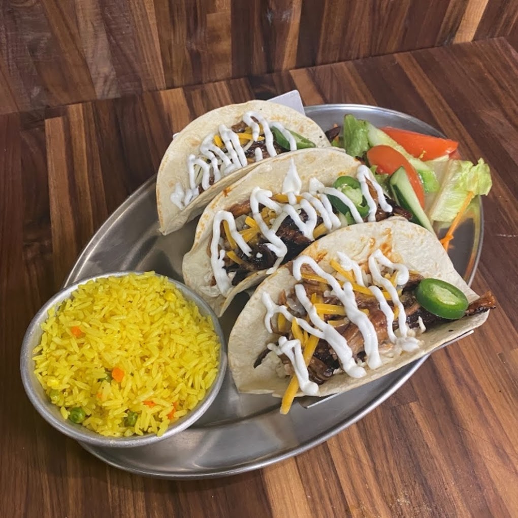 Three tacos and Mexican rice on the side