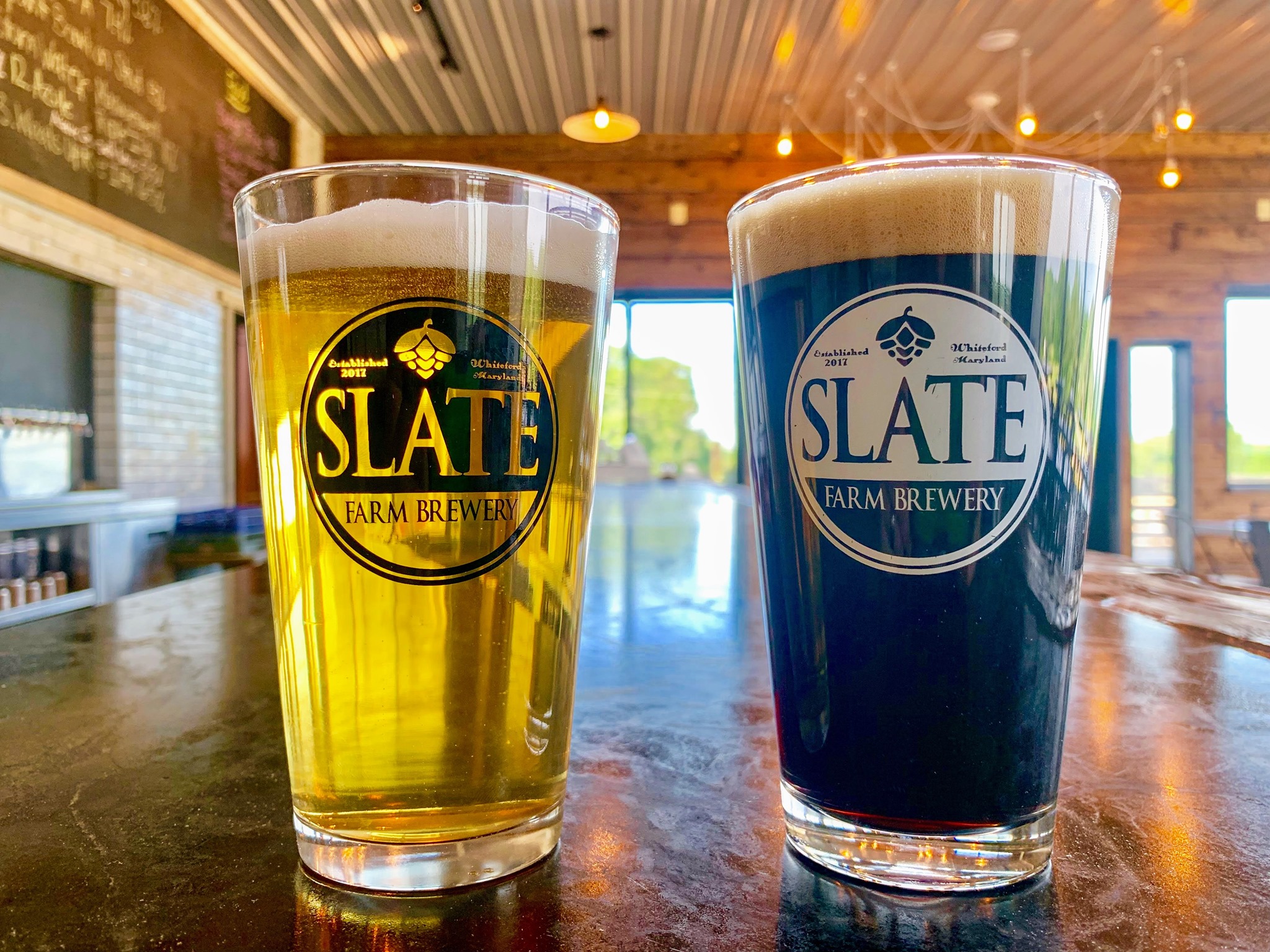 A yellow and a blue Draft Beer on a bar