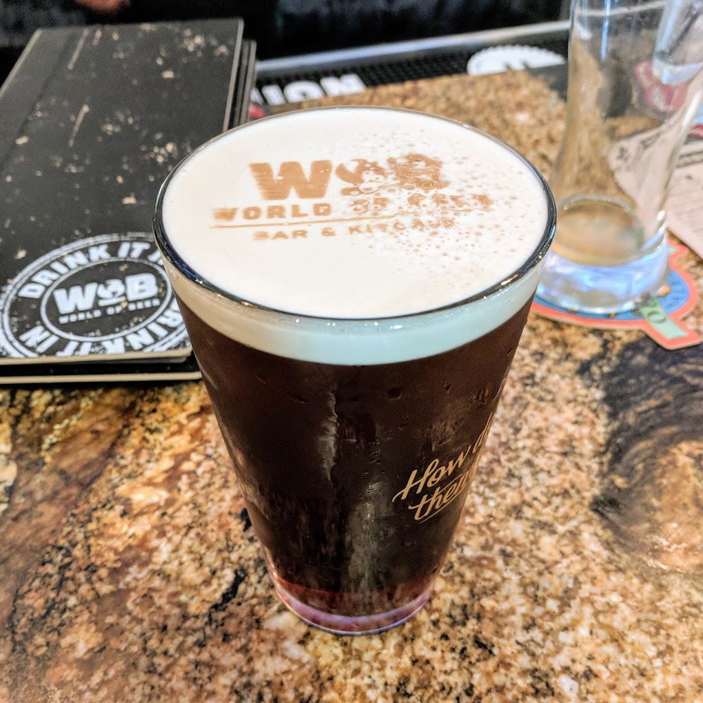 a pint with the World of Beer logo in the foam