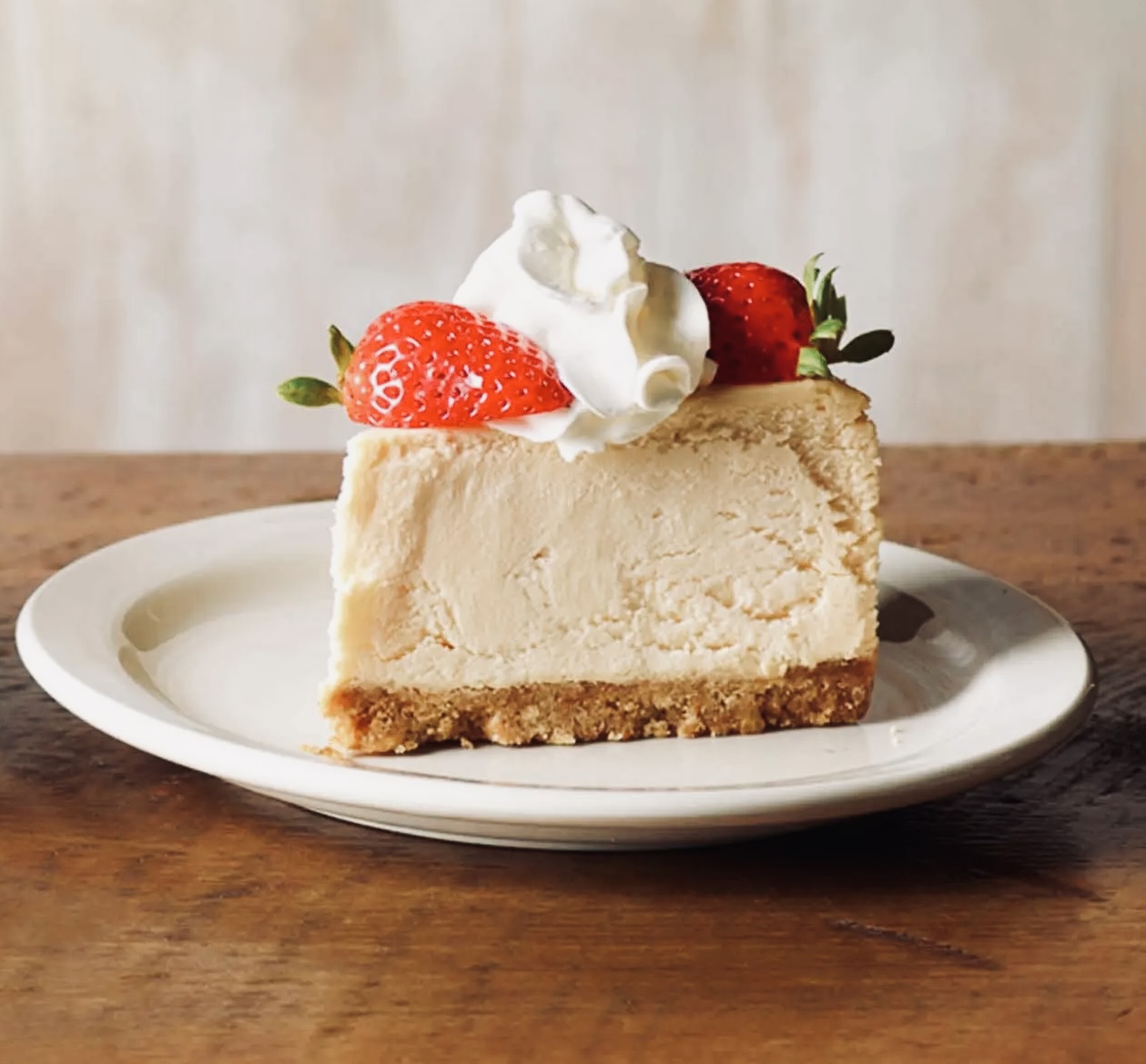 a slice of cheesecake with whipped cream and strawberries