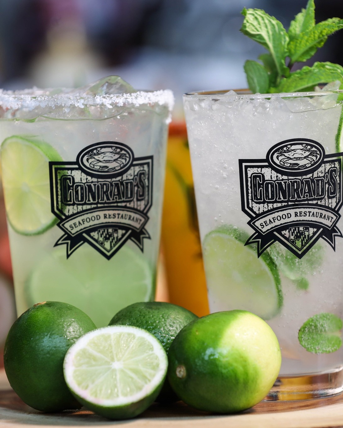 two mojitos with a pile of limes next to them