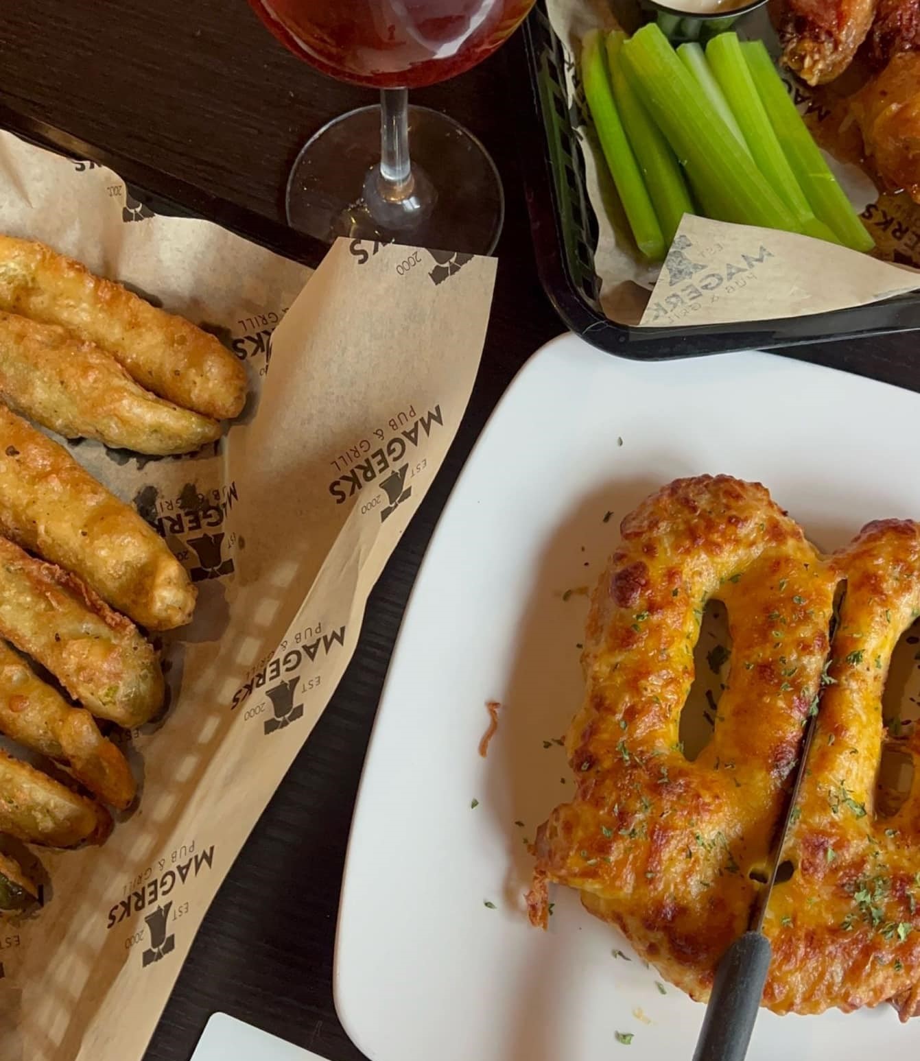 a crab pretzel on a plate and a basket of tempura pickles