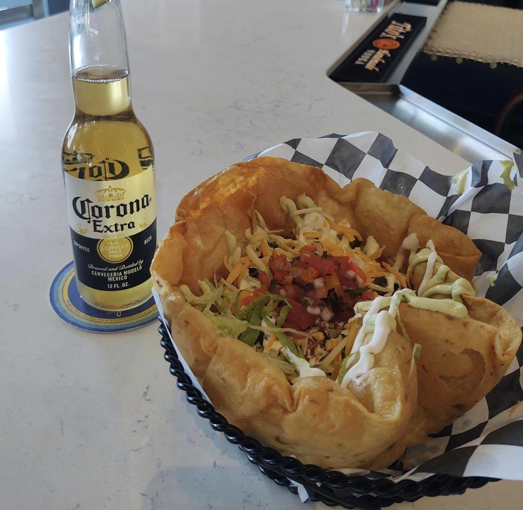 a taco salad with a bottle of beer