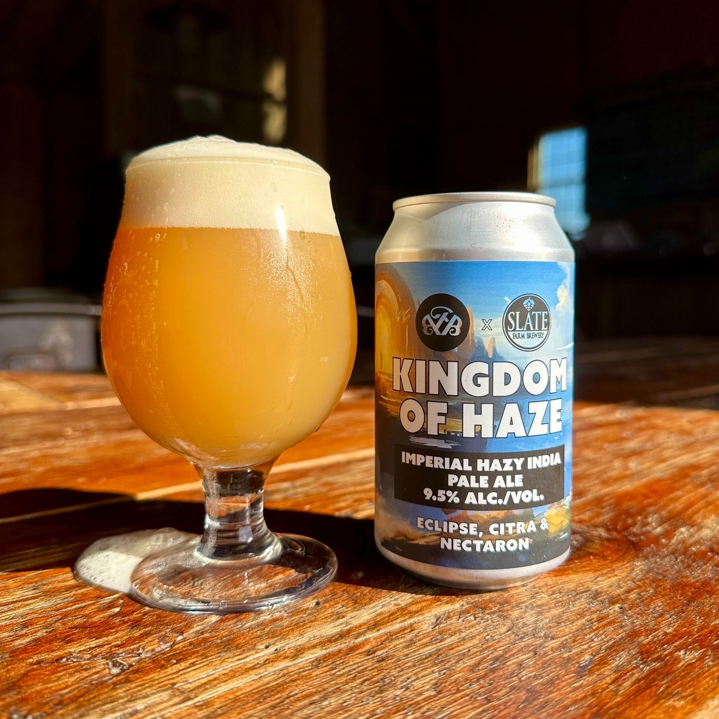 a glass and a can of "kingdom of haze" beer