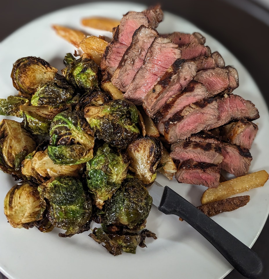a plate with steak, fries, and brussels sprouts