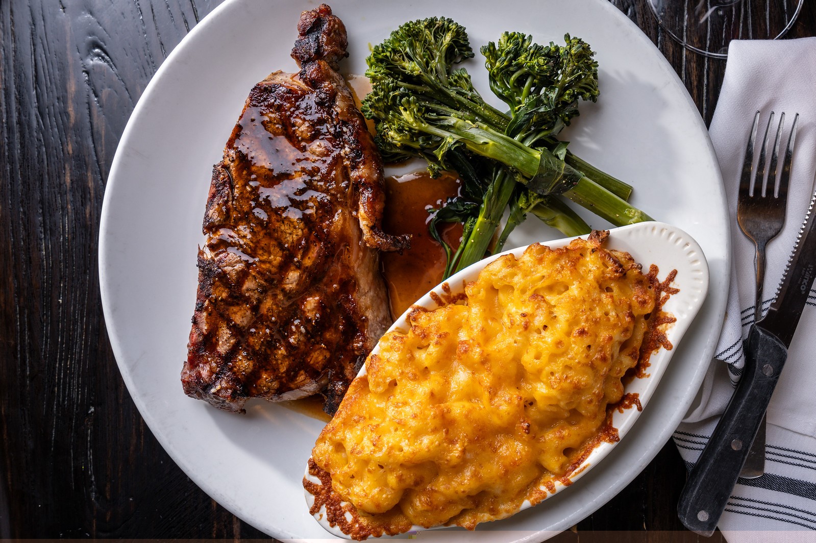 a plate of steak with broccoli and mac and cheese