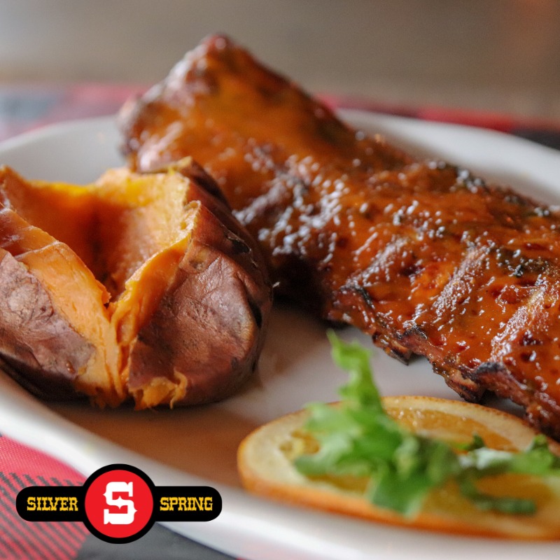 a plate of ribs and a baked sweet potato