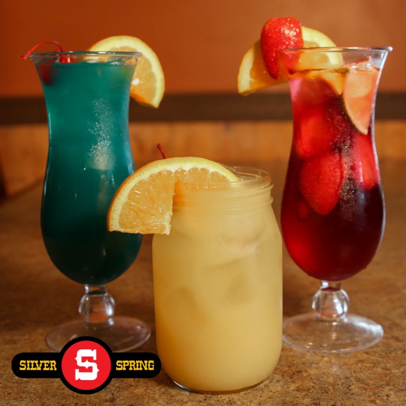 three cocktails, one blue, one yellow, and one red