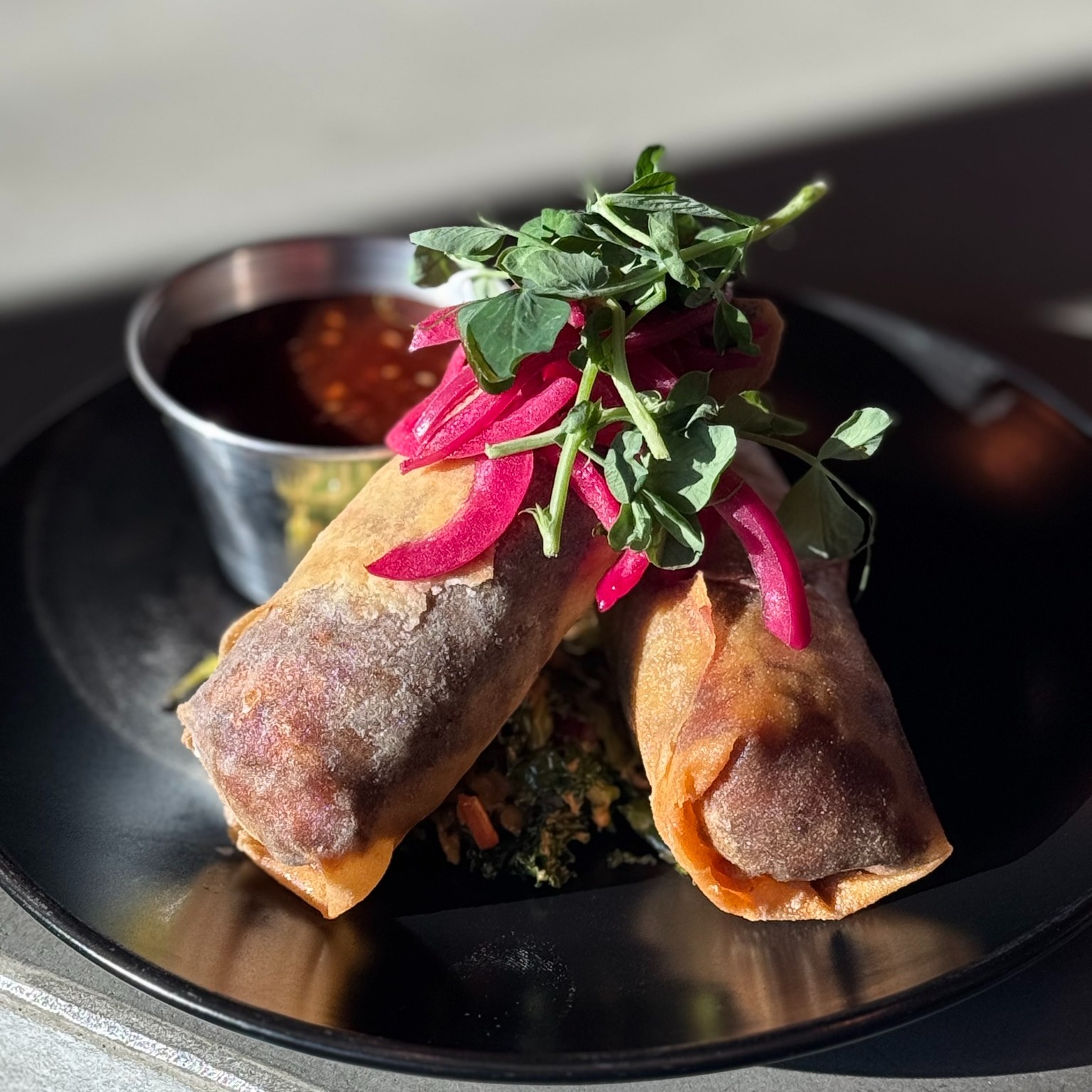 a plate of cheesesteak egg rolls