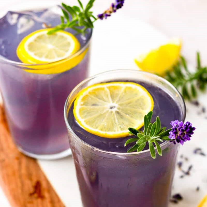a lavender crush - purple cocktail with a sprig of lavender and a lemon wheel