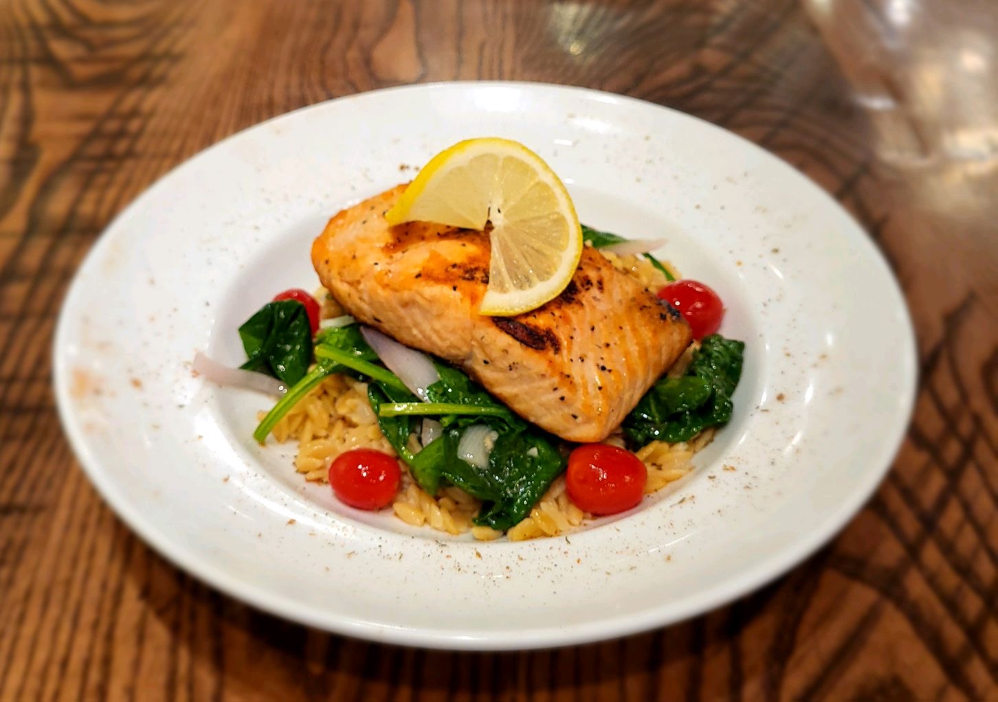 a plate of grilled salmon and orzo
