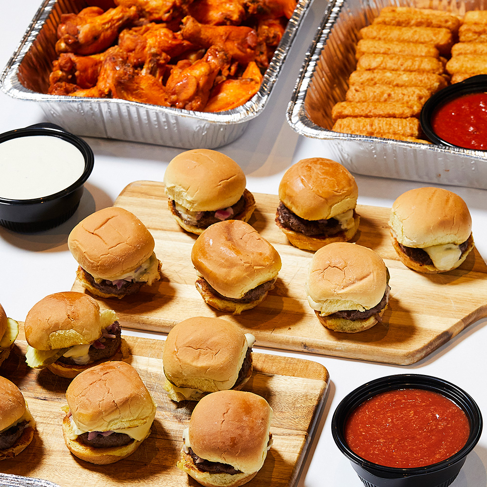 trays of sliders, wings, and mozzarella sticks with dips