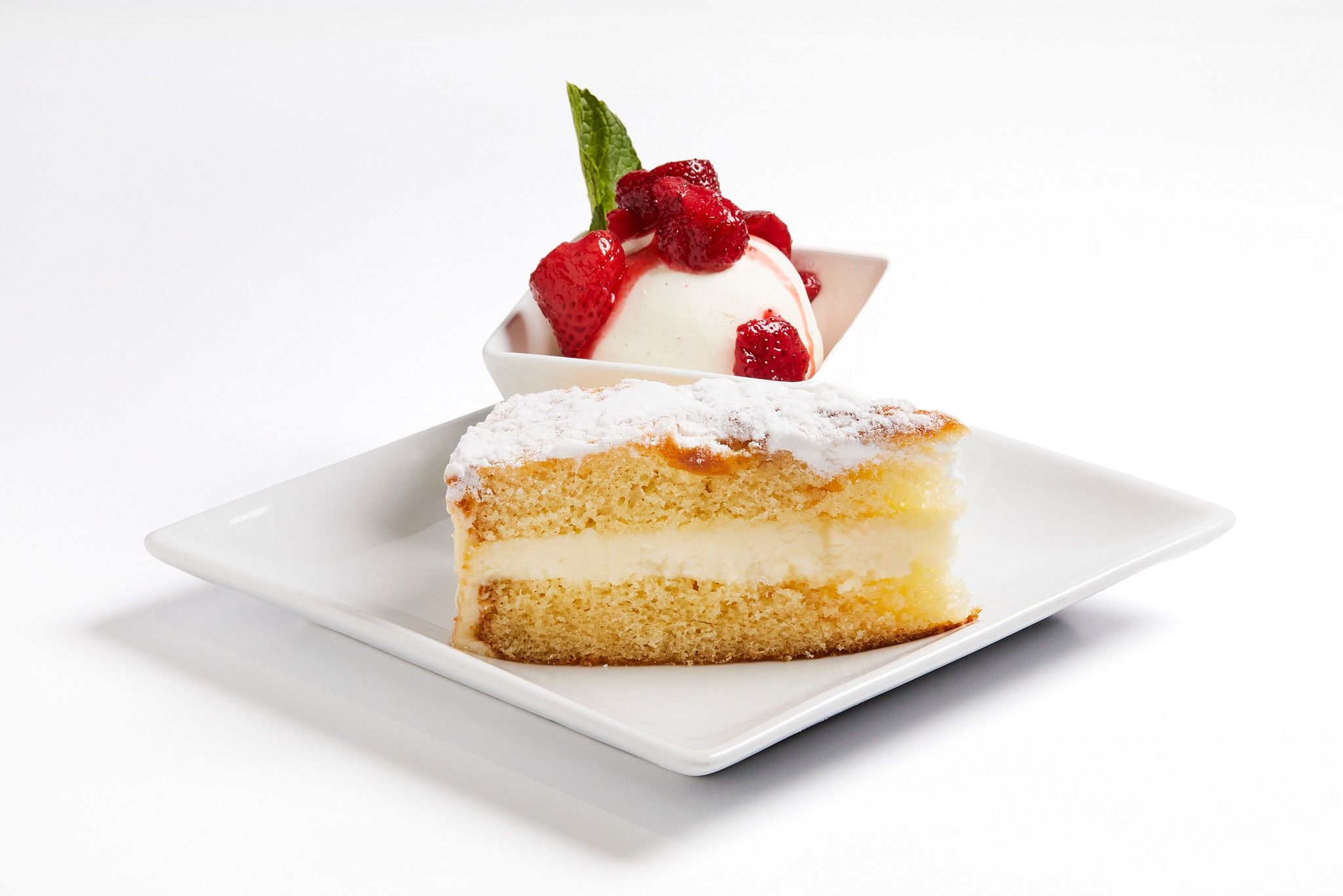 a slice of cake and ice cream with strawberries