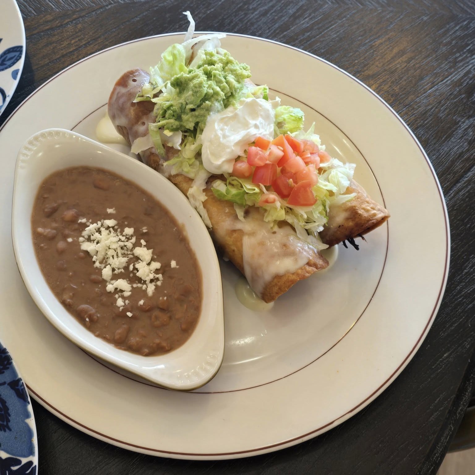 a plate of two enchiladas and refried beans