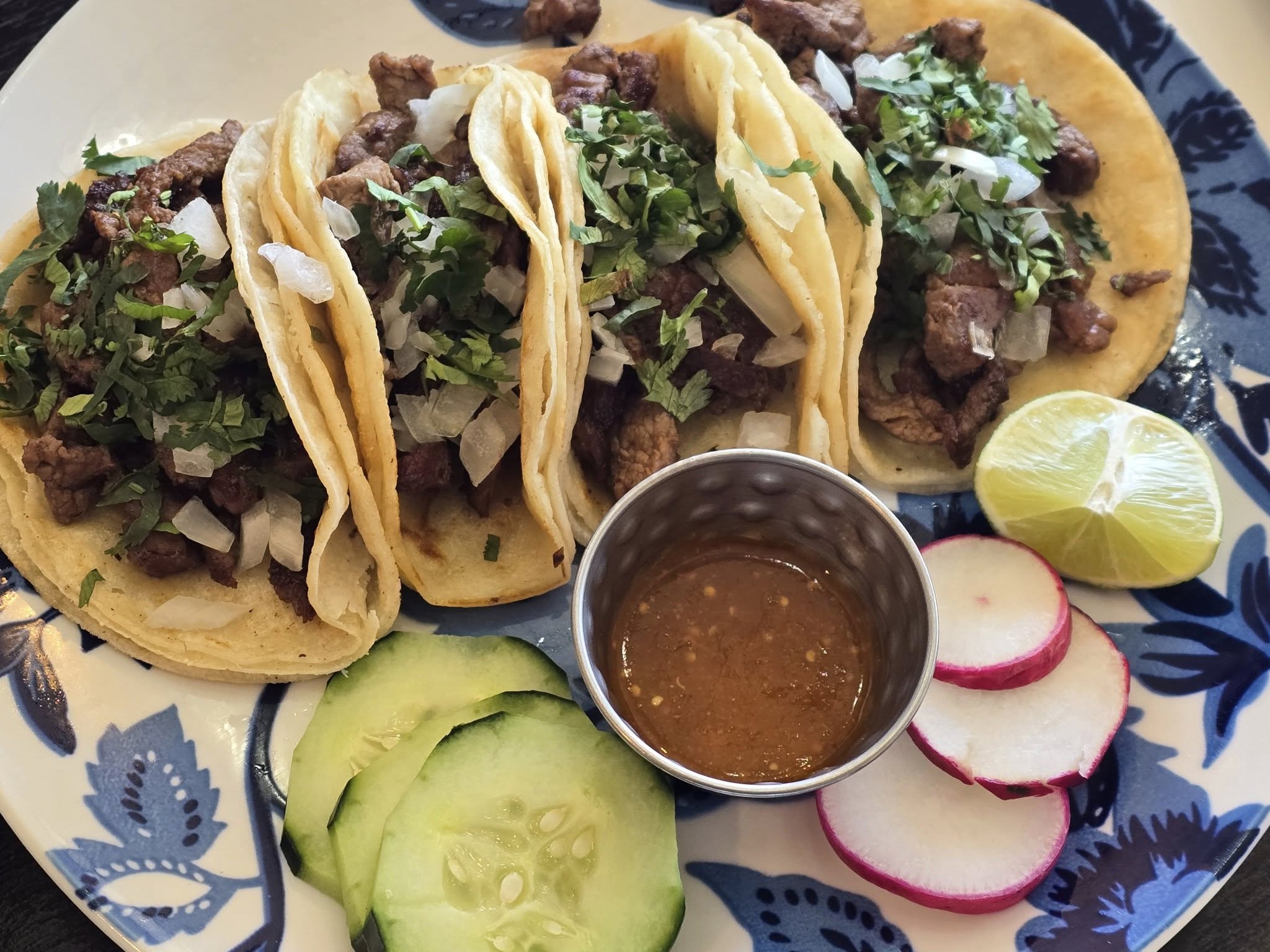 a plate of four soft shell tacos