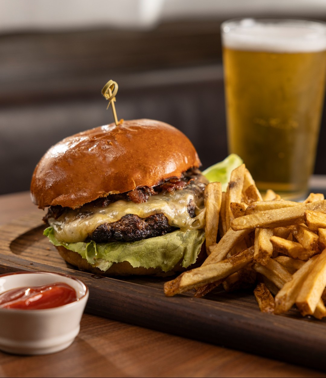 a charles burger with fries and a beer