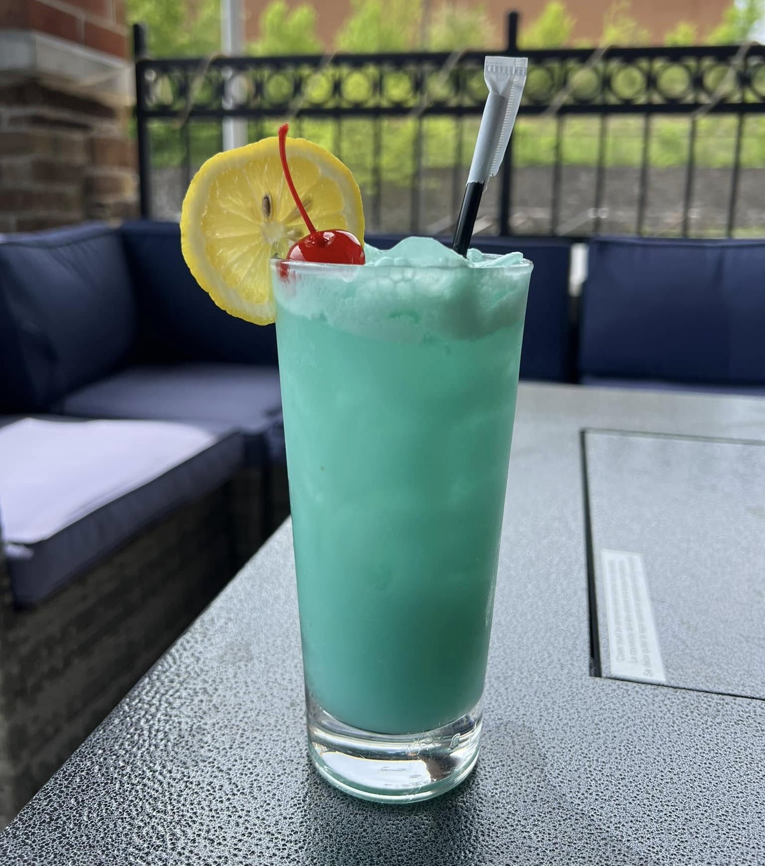 a Blue Hawaiian cocktail with a lemon wheel and a cherry