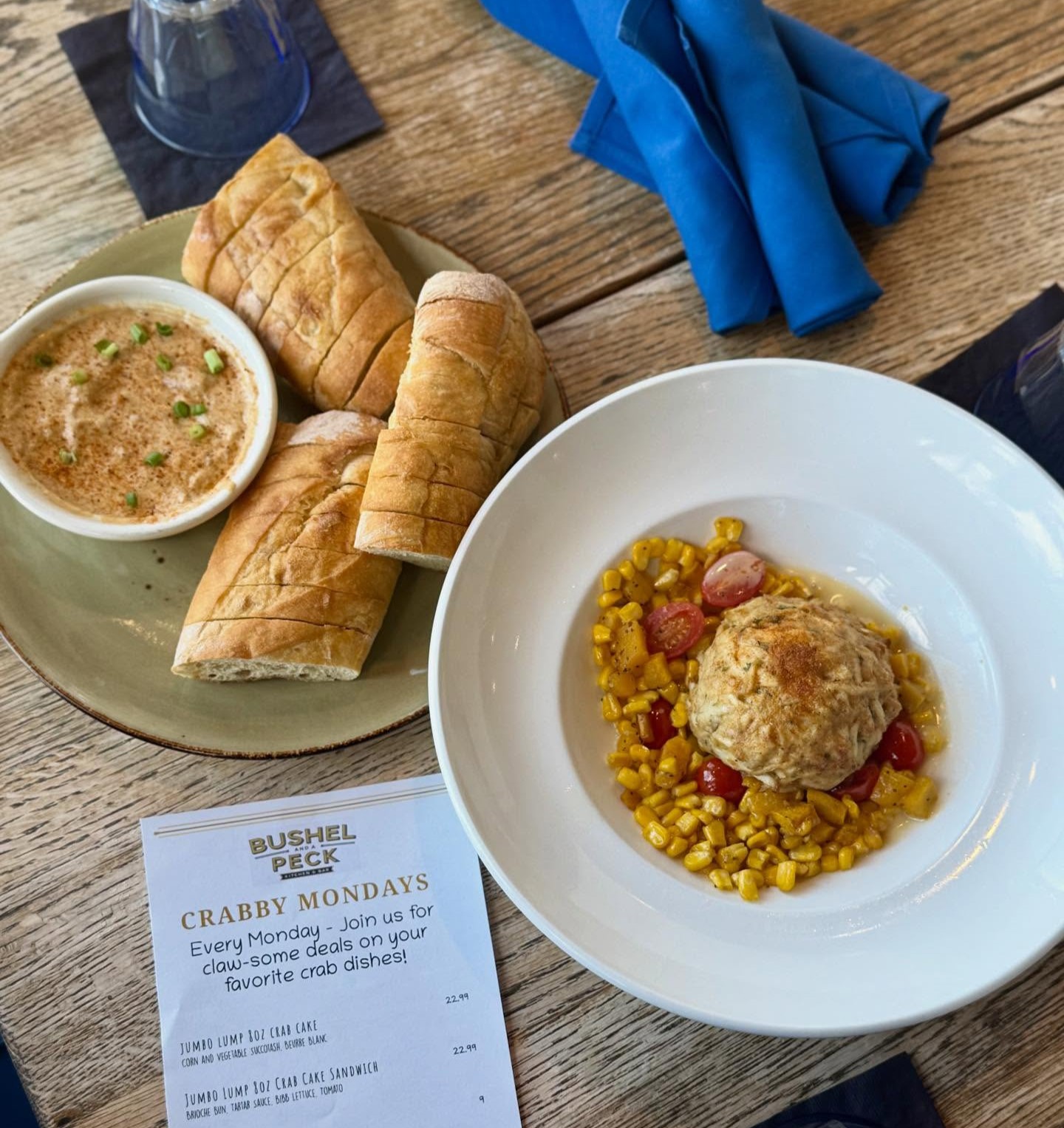 a jumbo lump crab cake and a bowl of crab dip with baguette