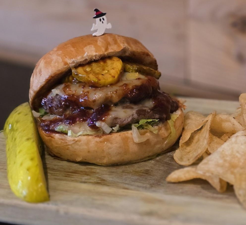 a Monster Smash burger with a pickle and potato chips
