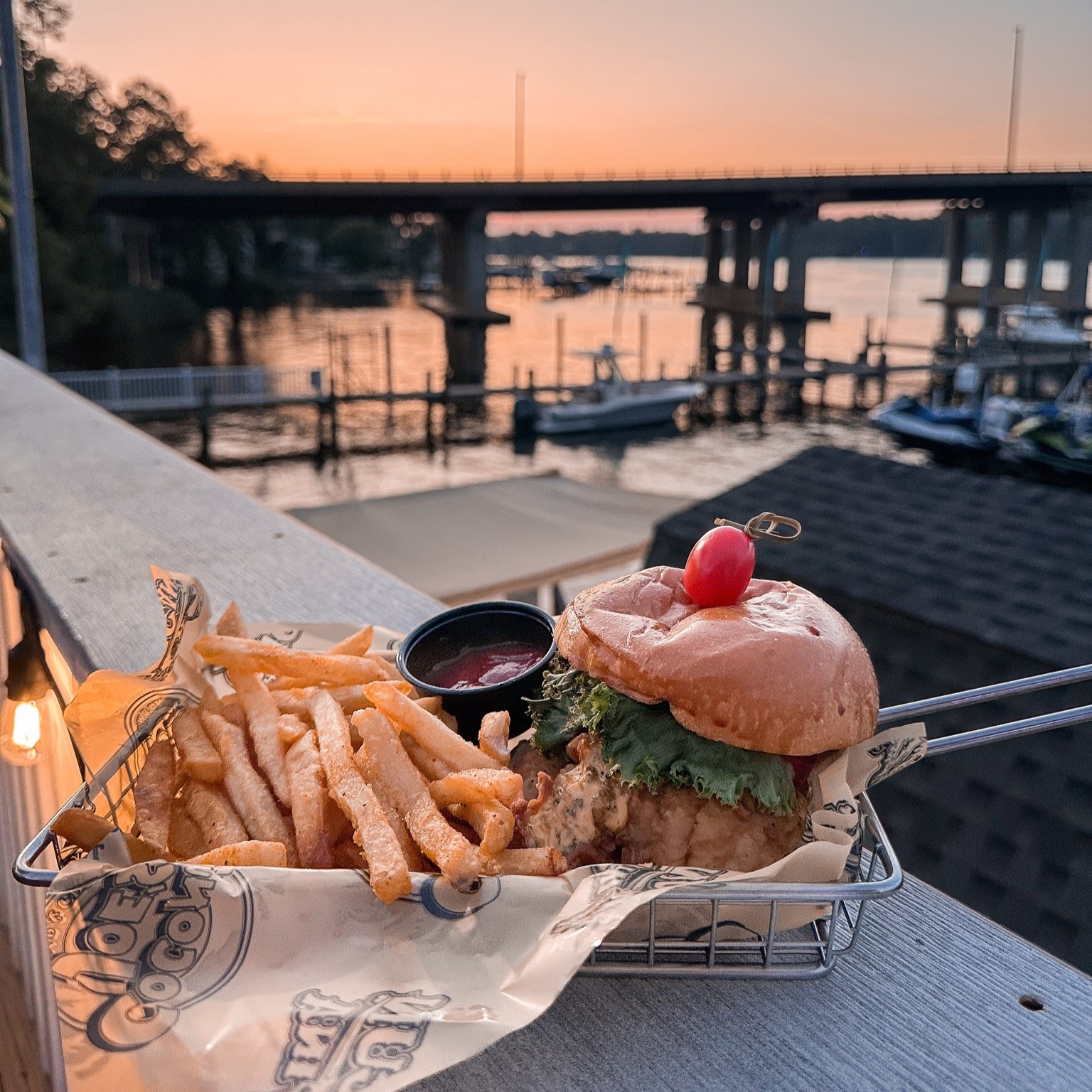 a burger with fries on a fence outside