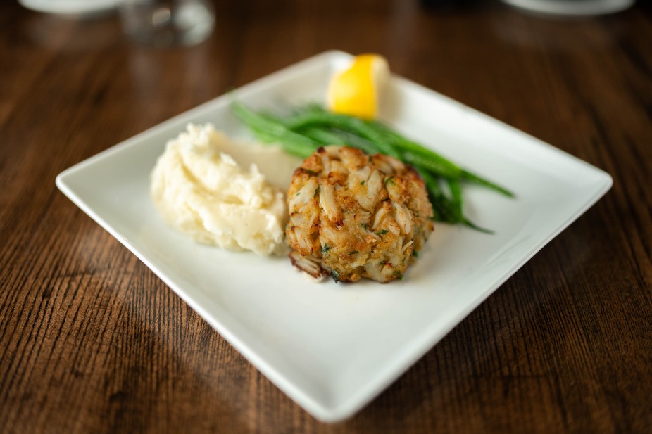 a crab cake with mashed potatoes and green beans