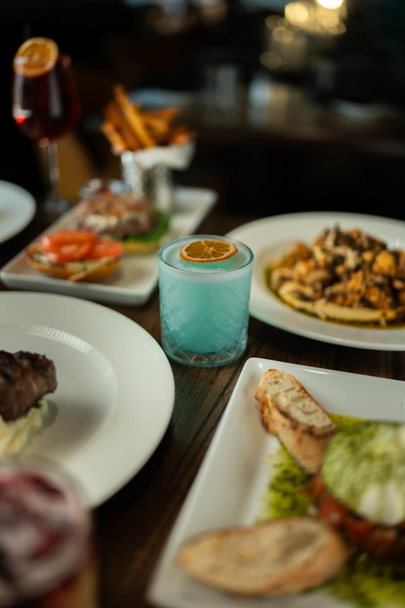 plates of various foods and a blue cocktail