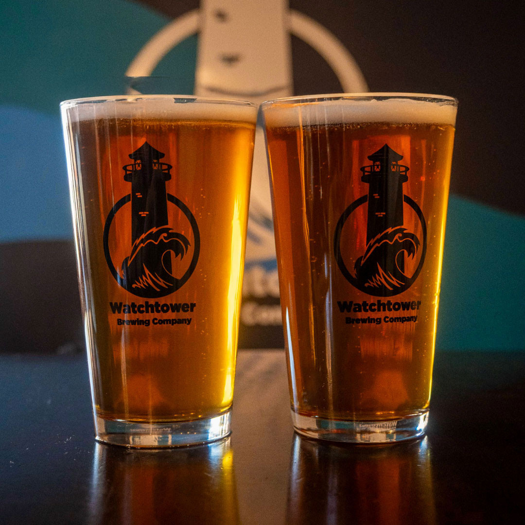 two glasses of beer in front of a colorful wall