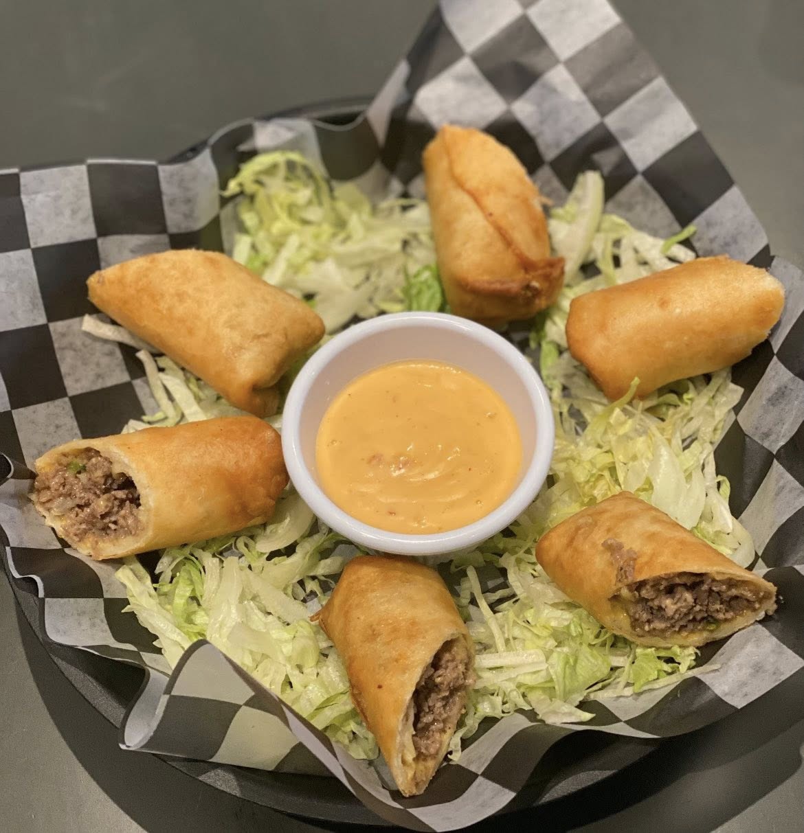 a plate of cheesesteak egg rolls