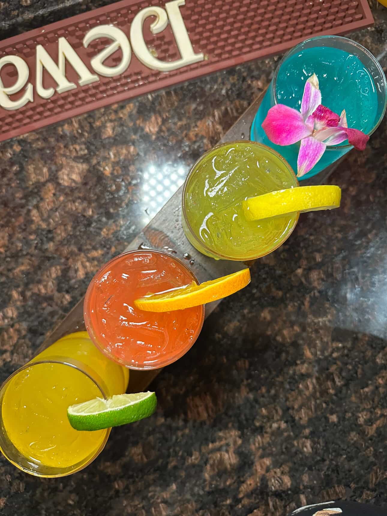 four colorful cocktails on a table
