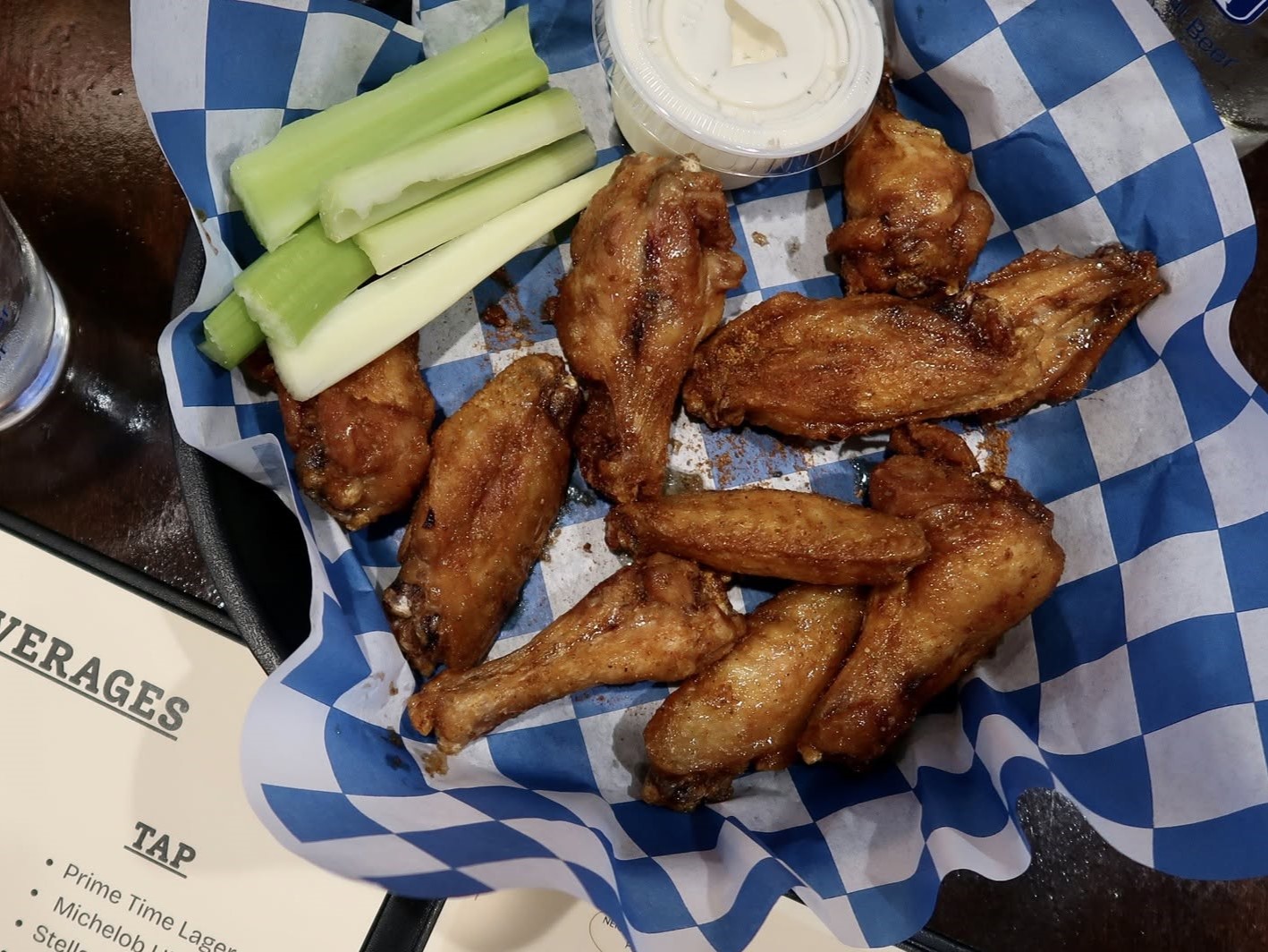 a basket of wings with celery and dip