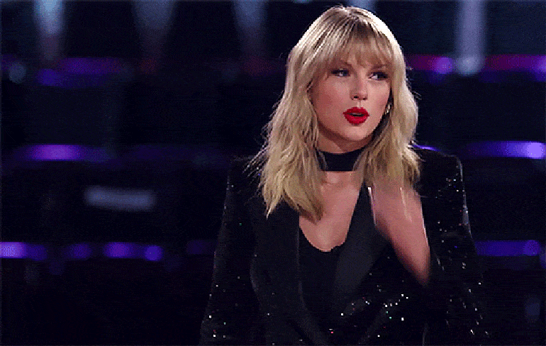 a gif of Taylor Swift doing a chef's kiss